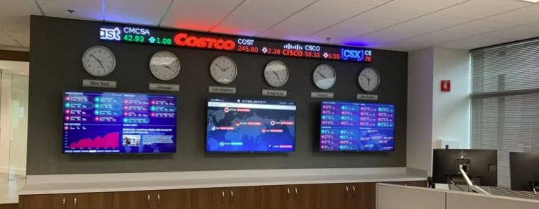Close-up of electronic financial market ticker numbers on a trading floor display.