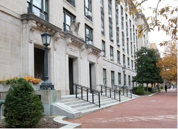 Large stone government building exterior facade under clear daylight.