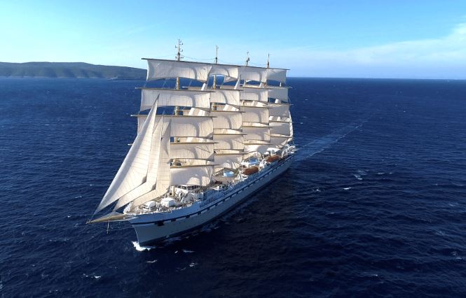 Large cruise ship cruising on the sea under clear skies.