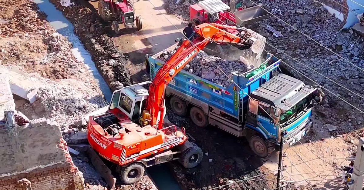 Heavy excavators operating at an urban waste management site.