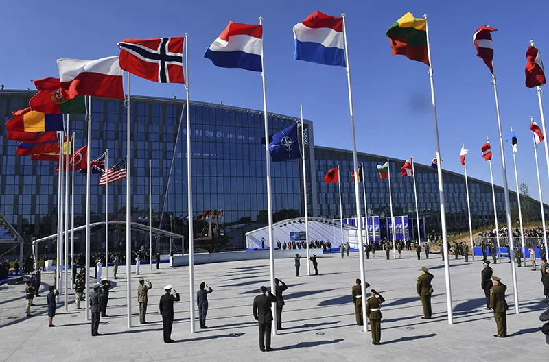 Flags of European nations fluttering outside an international summit venue.