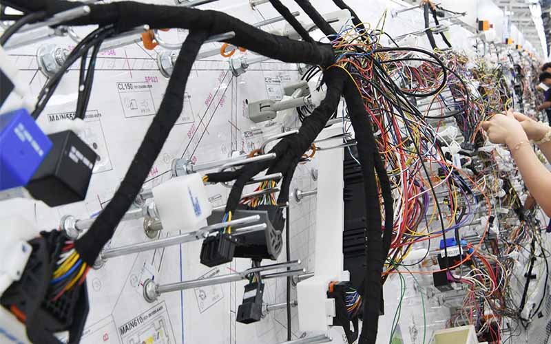 Automotive wire harness assembly on a manufacturing inspection board.