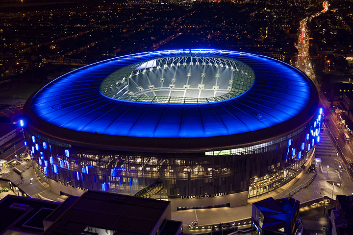 Tottenham Hotspur Stadium exterior illuminated ahead of international sports events.