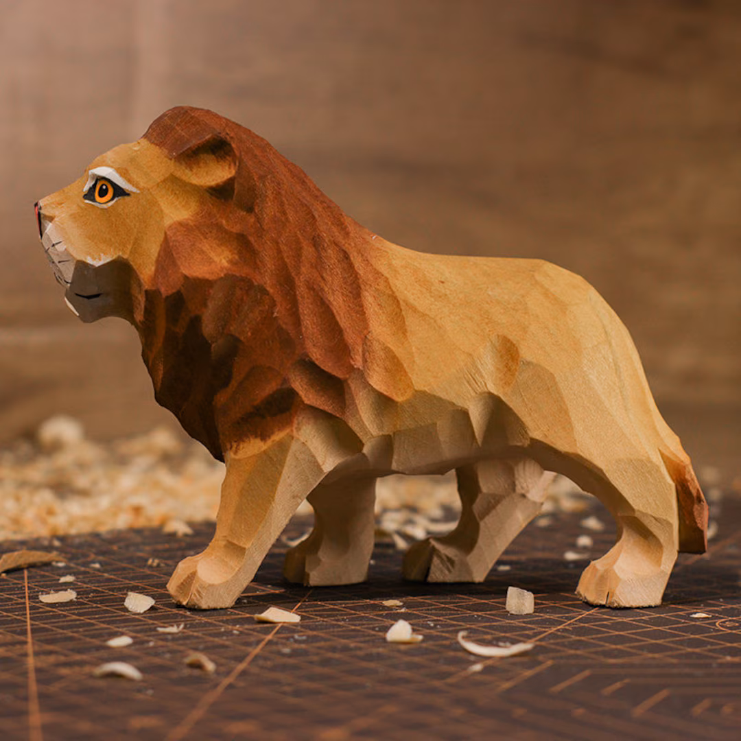Hand-carved wooden lion artifact displayed in a workshop.
