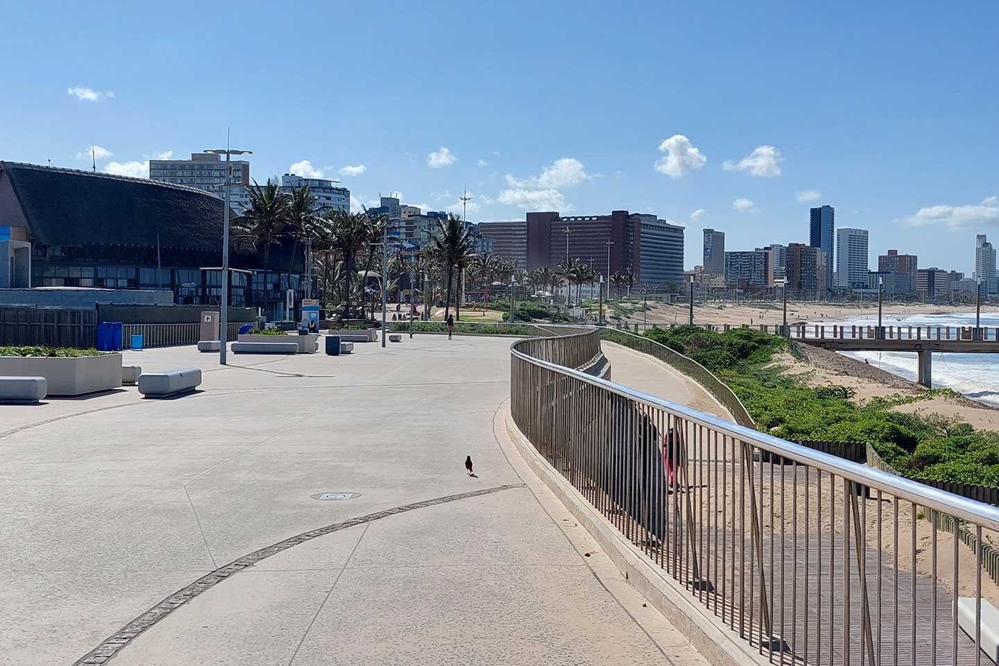 Tourists walking along a commercial waterfront promenade in Durban, South Africa.