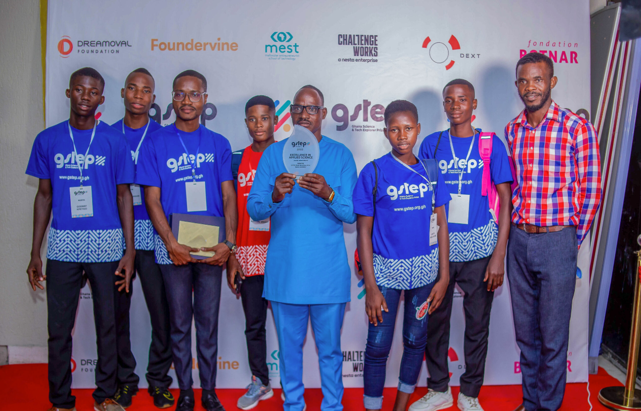 Students and mentors holding an award at the GSTEP exhibition in Ghana.