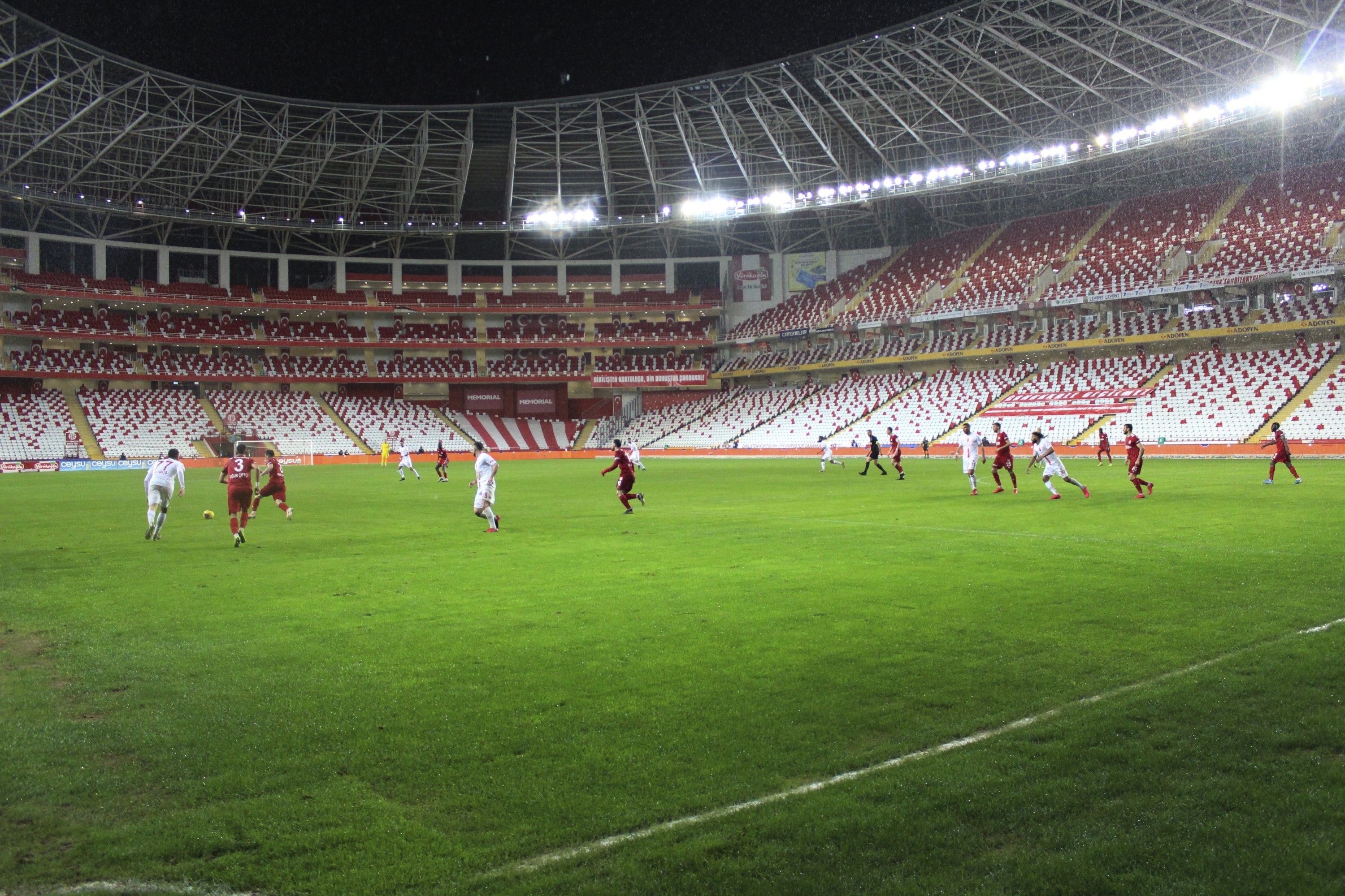 Players on the pitch during a Turkish Süper Lig match in a large stadium.