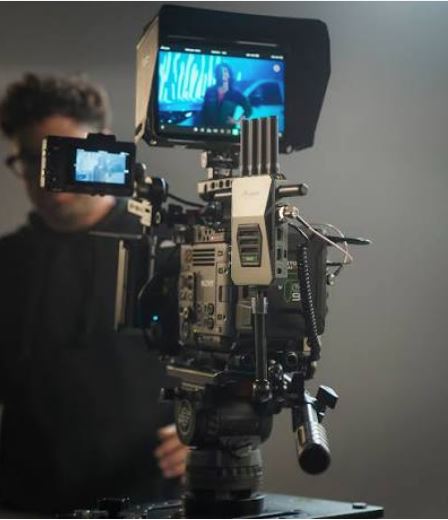 Professional cinema camera mounted on a tripod inside a studio.