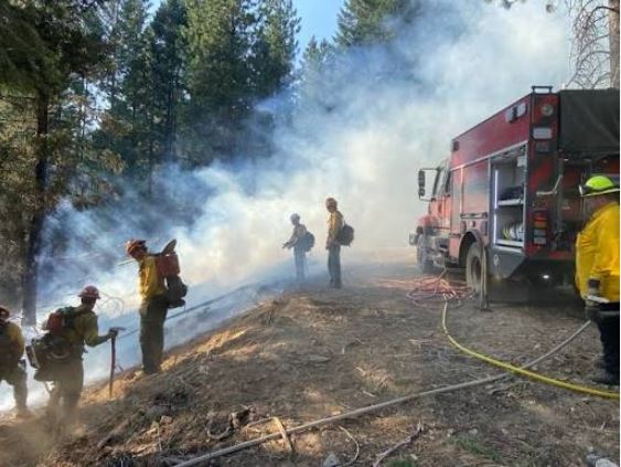 Emergency vehicle responding to a wildfire emergency in a rural landscape.