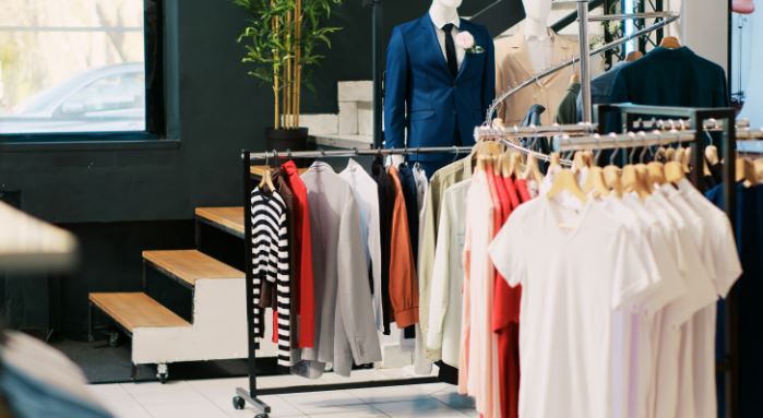 Clothing rails filled with modern designer apparel inside a bright retail showroom.
