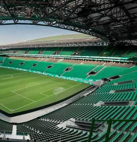 Green turf field inside a major European football arena.