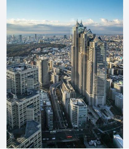 Modern office towers under a bright blue sky.