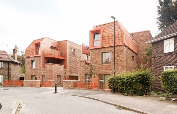 Urban residential street lined with classic brick townhouses in London.