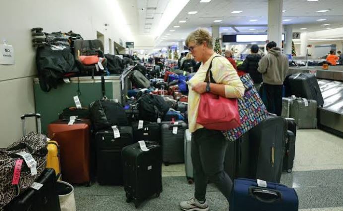 Stacked luggage and travel bags waiting inside an airport terminal baggage claim area.