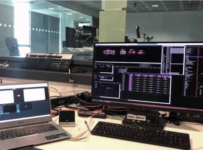 Computer screens displaying technical data graphs and schematics.